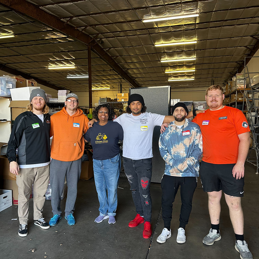 Our movers posing for a picture in a warehouse with team members from Chosen Ones organization.