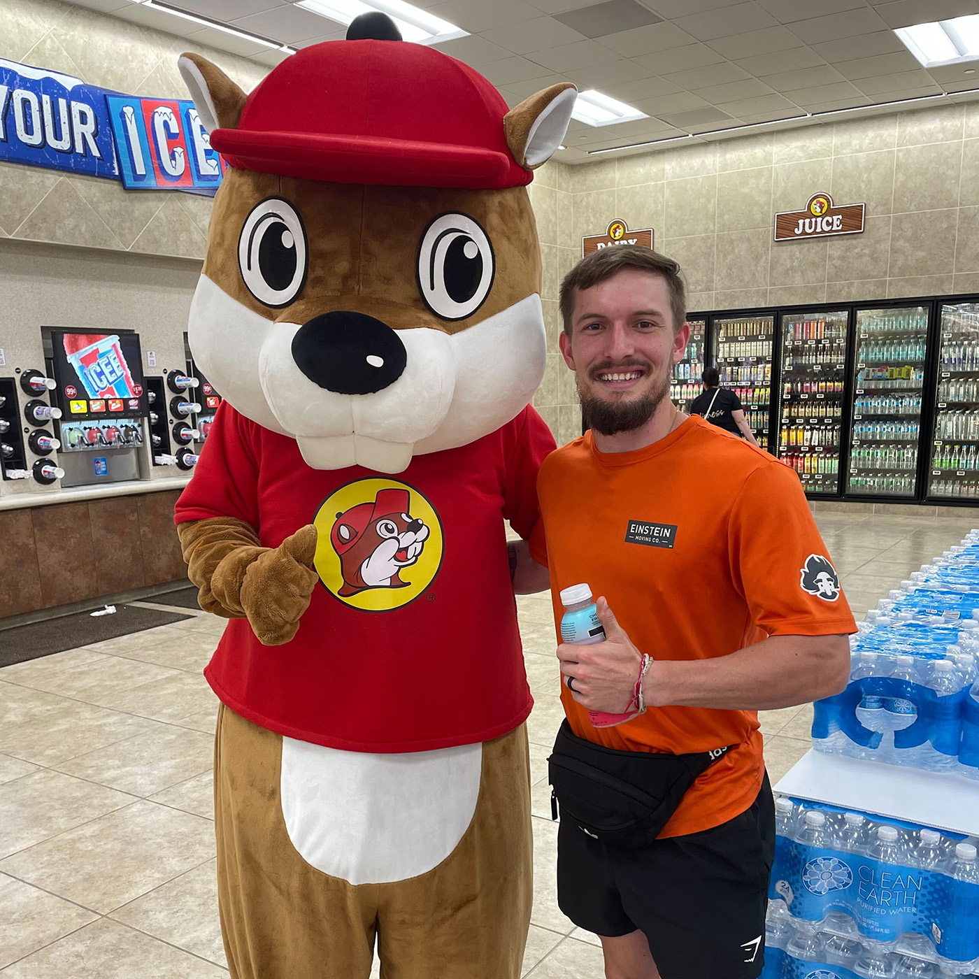 Einstein mover posing with a mascot in McKinney's Buc-ees.