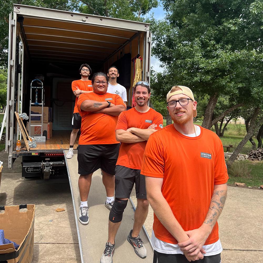 Group of friendly movers from Einstein Moving Company standing in front of an open moving truck, ready to assist with a move in Round Rock, TX.